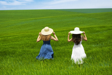 two girls in a wheat field, two friends enjoying the open air