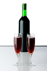 Bottle and wine glasses on reflective background