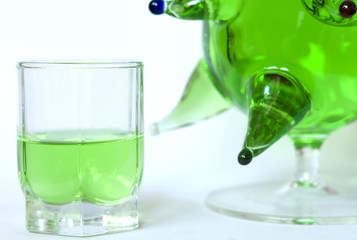 Small glass of absienthe with bottle
