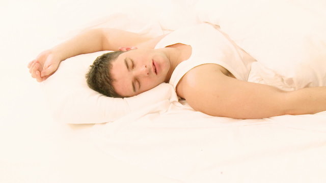 Attractive man sleeping in bed
