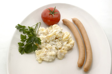 Kartoffelsalat mit zwei Wuerstchen und einer Tomate