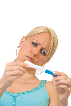 Femme blonde en train de lire un test de grossesse