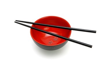 Chopsticks on  red and black bowl with kanji isolated