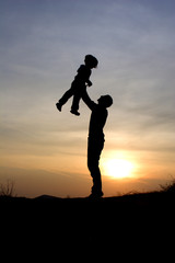 Fototapeta na wymiar fun and love of father and child in sunset - silhouette
