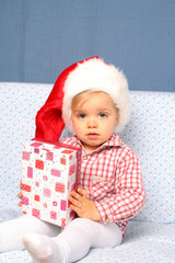 Kleinkind als Weihnachtsmann mit Geschenk