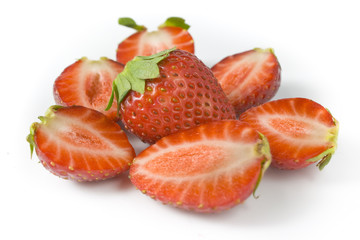whole strawberry and the berries of a strawberry cut on halves.