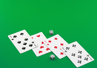 The dice and playing cards on green  background.