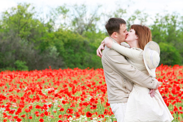 kissing couple in red poppies field