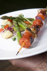 Grilled skewer on a plate with vegetables