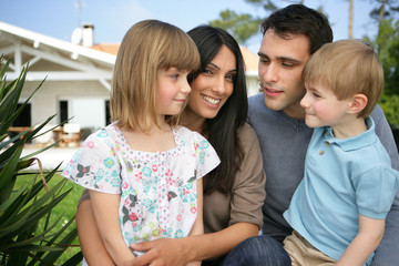 Family portrait standing outside in front of house