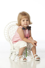 little girl in white wicker chair