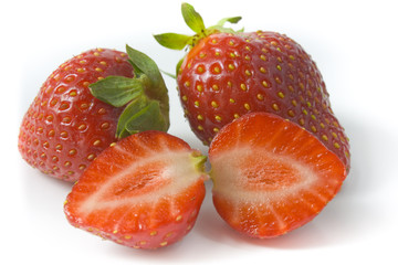 Two ripe strawberries and two segments of a strawberry
