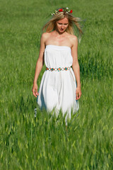 young beautiful girl walking in green field