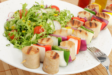 bratwurstspieß an buntem Salat