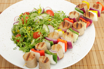 bratwurstspieß an buntem Salat