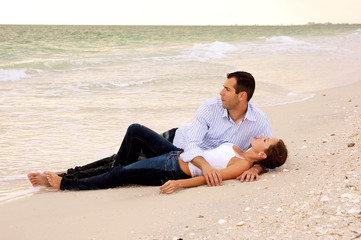 young lovers laying together on the beach
