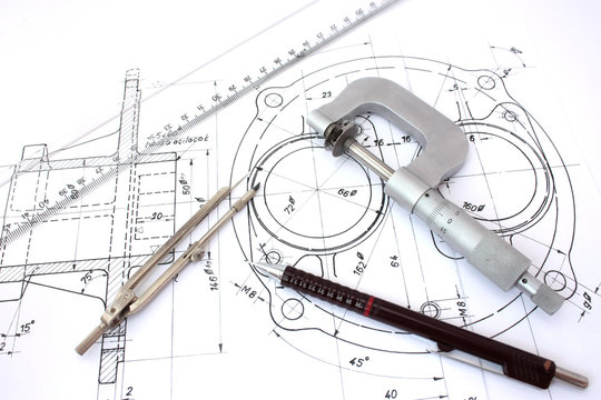 Micrometer, compass, ruler and pencil on technical drawings