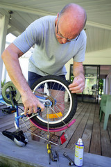 homme âgé réparant un vélo d'enfant