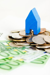 Housing market concept image with a pile of money and toy house