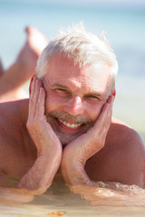 Homme senior souriant se baignant à la mer