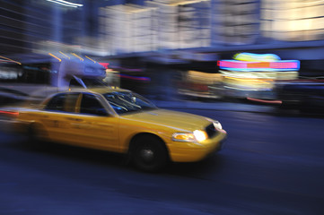 Fototapeta na wymiar Cab Taxi przyspieszenie w dół ulicy miasta w nocy