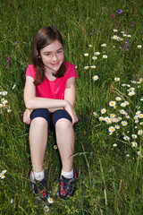Girl sitting on green meadow