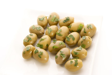 gruene Oliven auf einem weissen Teller