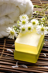 Fototapeta na wymiar Spa towel ,flower with soap on bamboo mat