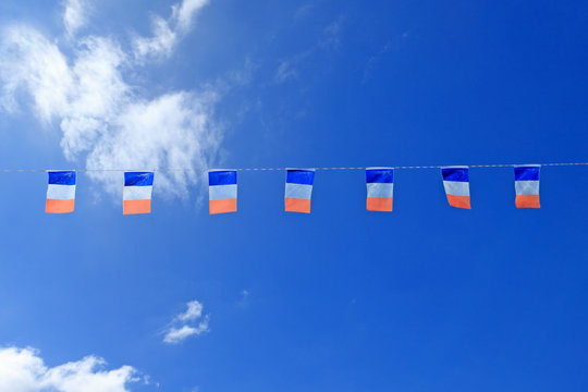 guirlande de drapeaux tricolores sur fond de ciel bleu