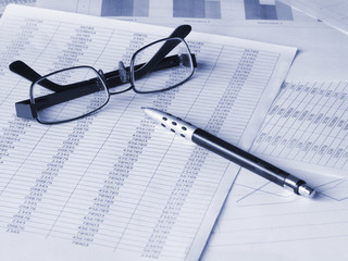 Pen and glasses on financial documents