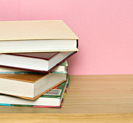 Pile of colorful books isolated on pink background