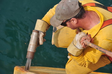 seaman removes rust from ship's hull - 14439619