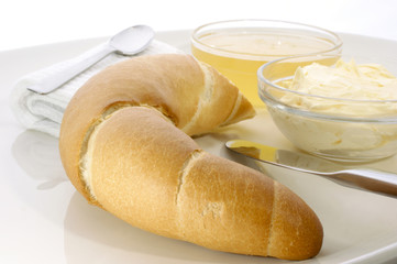 Broetchen mit Honig zum Fruehstueck serviert