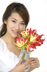 Young woman hands holding vase with flowers.