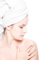 Woman in towel applying cream
