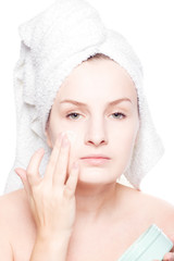 Woman in towel applying cream