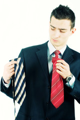 Young business man deciding with tie to wear