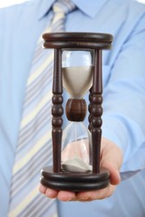 Businessman with hourglass as "deadline"