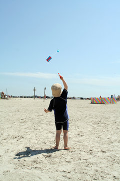 Kleiner Junge am Strand mit Drachen