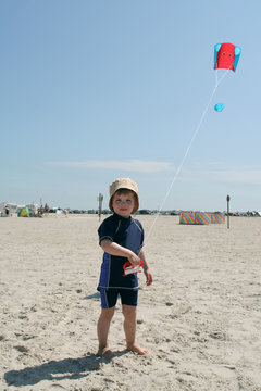 Kleinkind am Strand mit Drachen
