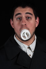 funny male with lightbulb in mouth isolated on black background