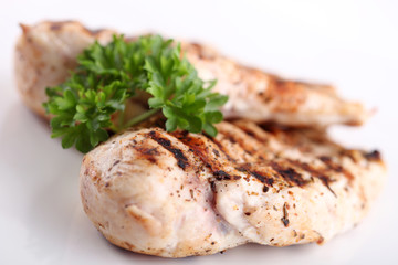 Grilled chicken breasts on a plate with fresh vegetables