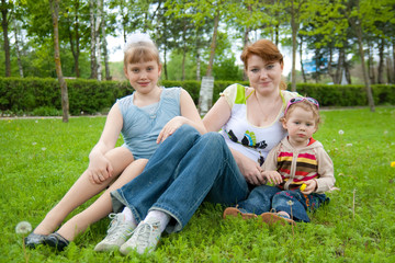 family sit on green grass