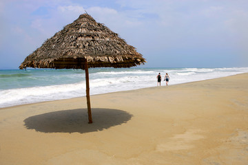 Thatched umbrella on deserted beach, Hoi An Vietnam