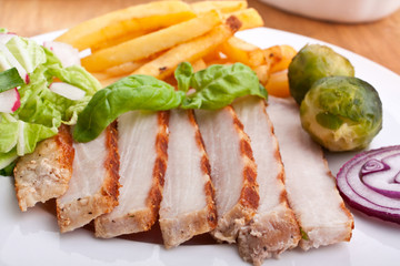 sliced pork chops with fries and brussels sprouts