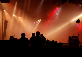 Silhouette von Tontechnikern vor Bühnenlicht