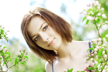 Naklejka premium Beautiful girl among the blooming trees
