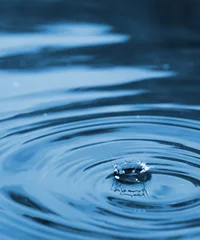 Fotobehang Droplet falling in blue water © Nejron Photo