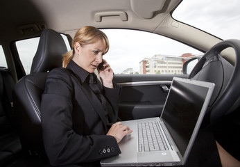 Fototapeta na wymiar Businesswoman with a laptop in her car