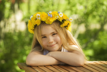 Portrait of a little girl in wreath of flowers